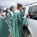 Port Angeles High School graduates, from left, Uri Crawford, Samantha Combs and Jordan McTear, decorate a vehicle in preparation for Fridays graduation parade from Ediz Hook to the high school. Dozens of adorned cars and trucks carried grads through the streets of Port Angeles as a lead-up to the graduation ceremony that evening at Civic Field. (Keith Thorpe/Peninsula Daily News)