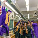 Quilcene senior Dominic Smith stands on a table to get an elevated selfie with his classmates before Saturdays graduation at the high school. (Steve Mullensky/for Peninsula Daily News)