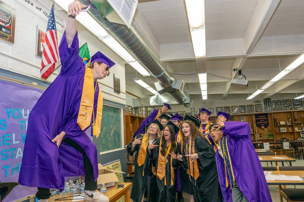 Quilcene senior Dominic Smith stands on a table to get an elevated selfie with his classmates before Saturdays graduation at the high school. (Steve Mullensky/for Peninsula Daily News)