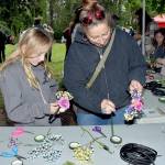 Elora Wilson, 10, and her mother, Eria Wilson of Sequim, create solstice crowns to wear on their heads at a craft table in Websters Woods Sculpture Park at the Port Angeles Fine Arts Center during Saturdays Summertide Solstice Art Festival. The event featured music entertainment, poetry reading, crafts, food and games as a celebration of the upcoming beginning of summer and the longest day of the year. (Keith Thorpe/Peninsula Daily News)