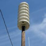 Joshua Percival of the Washington State Emergency Management Agency at Camp Murray installs a communications antenna on the recently replaced tsunami alert siren near Port Angeles Boat Haven on Friday in preparation for bringing a second siren into the downtown area online. The original siren at the same location was destroyed when an automobile struck the pole in April 2023, sending the siren crashing to the ground. The unit supplements a siren at First and Lincoln streets, covering the central Port Angeles area. (Keith Thorpe/Peninsula Daily News)