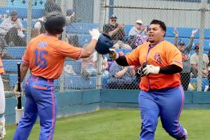 Spencer Dickinson of Saipan and is greeted at home plate at Civic Field on Sunday by teammate Zach Blair after hitting a home run for the Port Angeles Lefties. (Dave Logan/for Peninsula Daily News)