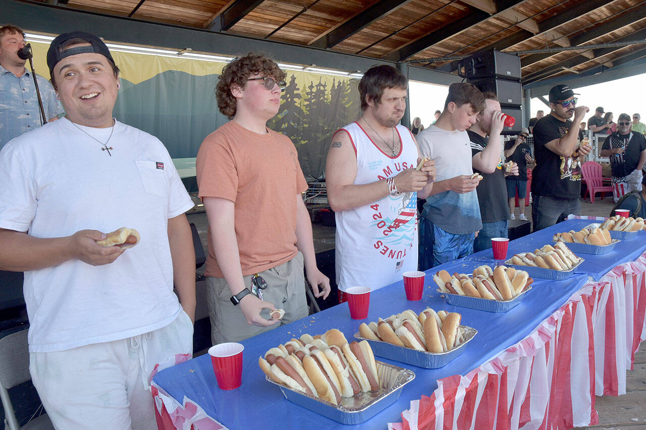 Hot dog eating contestants, from left, Jericho Stuntz of Port Angeles, Lincoln Forrest of Port Angeles, Sebastian Gagnon of Port Angeles, Leo Chouinard of Waupaca, Wisc., Ian Bravender of Port Angeles and Rickie Sanchez of Portland, Ore., chow down on hot dogs during Thursdays Independence Day contest at Port Angeles City Pier. Stantz won the contest by eating 8 1/2 hot dogs in 10 minutes, earning him a $10 cash card from Swains General Store. (Keith Thorpe/Peninsula Daily News)