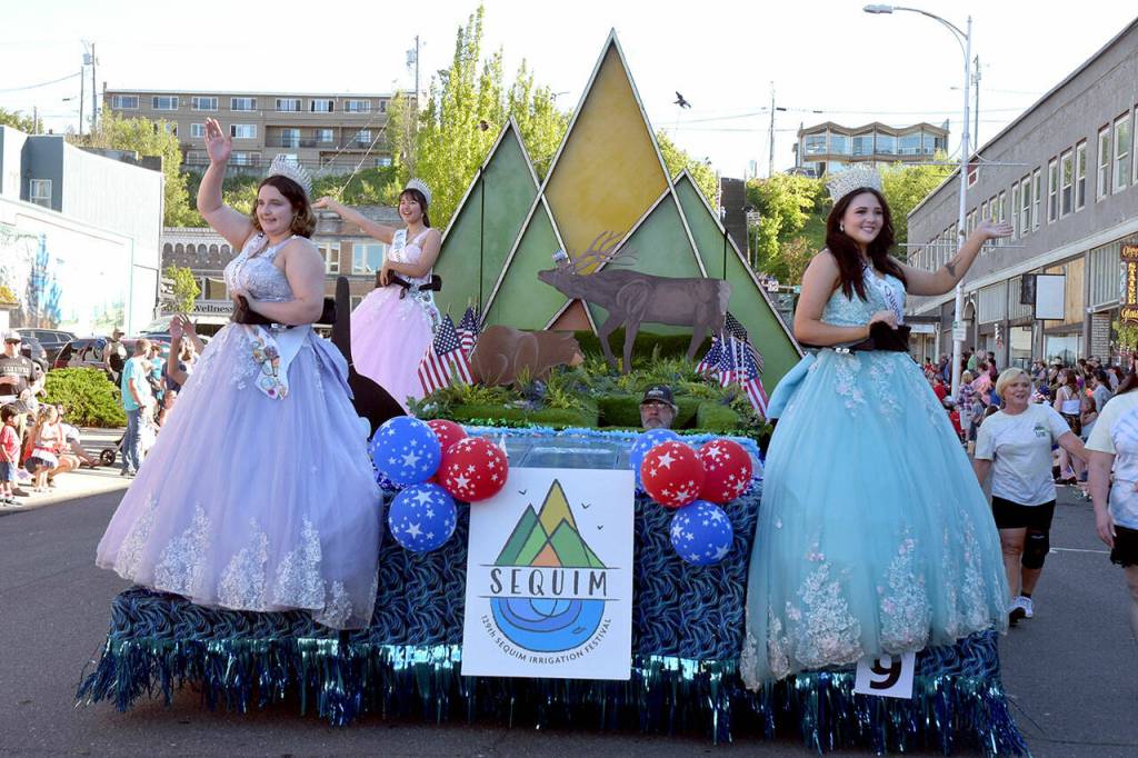 Sequim Irrigation Festival royalty, from left, Princess Ashlynn Northaven, Princess Kailah Blake and Queen Ariya Goettling ride on their festival float on Independence Day in Port Angeles. (Keith Thorpe/Peninsula Daily News)