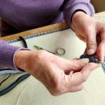 Paulette Hill, a jewelry artist, wire wrapping a Botswana agate cabochon.