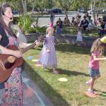 Childrens music singer Sarah Schwiethale of Port Angeles, front, along with helper Georgia Anderson, far left, leads youngsters through a song on the lawn of the Port Angeles Public Library on Saturdays Day of Play, a celebration of summer activities. The event, hosted by the Port Angeles Parks & Recreation Department, featured a wide variety of things to do for children and adults at venues scattered across the city. (Keith Thorpe/Peninsula Daily News)