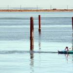 A kayker makes his way between the pilings of a former floating log yard near the entrance to Port Angeles Boat Haven. Pleasant conditions and calm waters are expected across most of the North Olympic Peninsula through the coming weekend. (Keith Thorpe/Peninsula Daily News)