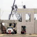 Abbot Constructions crew responsible for crane lifting the two-story concrete walls pack up as new crew members move in for steel reinforcement on Monday. (Elijah Sussman/Peninsula Daily News)