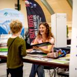 Maya DeLano, executive assistant at Composite Recycling Technology Center, demonstrates the durability of recycled carbon fiber during a job fair on Friday organized by the Port Angeles Chamber of Commerce at the Vern Burton Community Center. (Christopher Urquia/Peninsula Daily News)