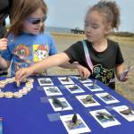 Riley Lohman, left, and Arya Davis, both 6, of Port Angeles, play a matching game of sea life at an activity table setup by the Olympic Coast National Marine Sanctuary during a 30th birthday party for the sanctuary at Waterfront Park. The celebration included information and activity booths from a variety of environmental stewardship groups, including the Feiro Marine Life Center, which will soon share a building at the location with the marine sanctuary. (Keith Thorpe/Peninsula Daily News)