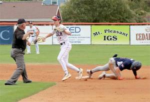 An umpire gives an emphatic out sign as Wilder Senior shortstop Alex Angevine applies a tag to a Twin-Cities Titans player at second base in Sunday nights AAA state tournament game at Civic Field. (Dave Logan/for Peninsula Daily News)