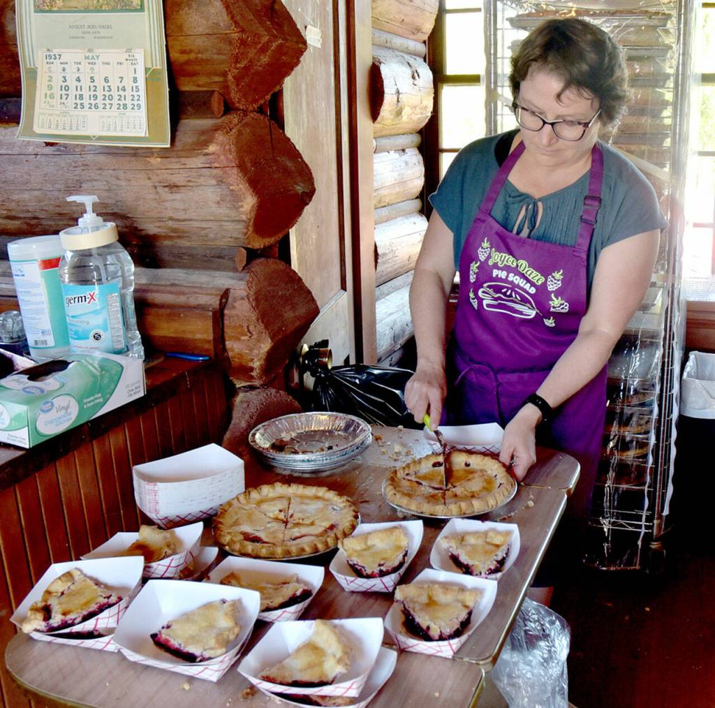 Trisha Haggerty of Joyce cuts slices of wild blackberry pie for festival-goers during Joyce Daze on Saturday. (Keith Thorpe/Peninsula Daily News)