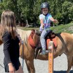 50 young ones signed up to take part in Fox-Bell Farm Trainings Hawaiian themed Kids Camp last weekend, including McCoy Sprenger, 7, on Moon, who played a ring toss game as instructor Sofie Feik looked on. (Photo by Mike Sprenger)