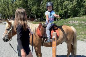 50 young ones signed up to take part in Fox-Bell Farm Trainings Hawaiian themed Kids Camp last weekend, including McCoy Sprenger, 7, on Moon, who played a ring toss game as instructor Sofie Feik looked on. (Photo by Mike Sprenger)