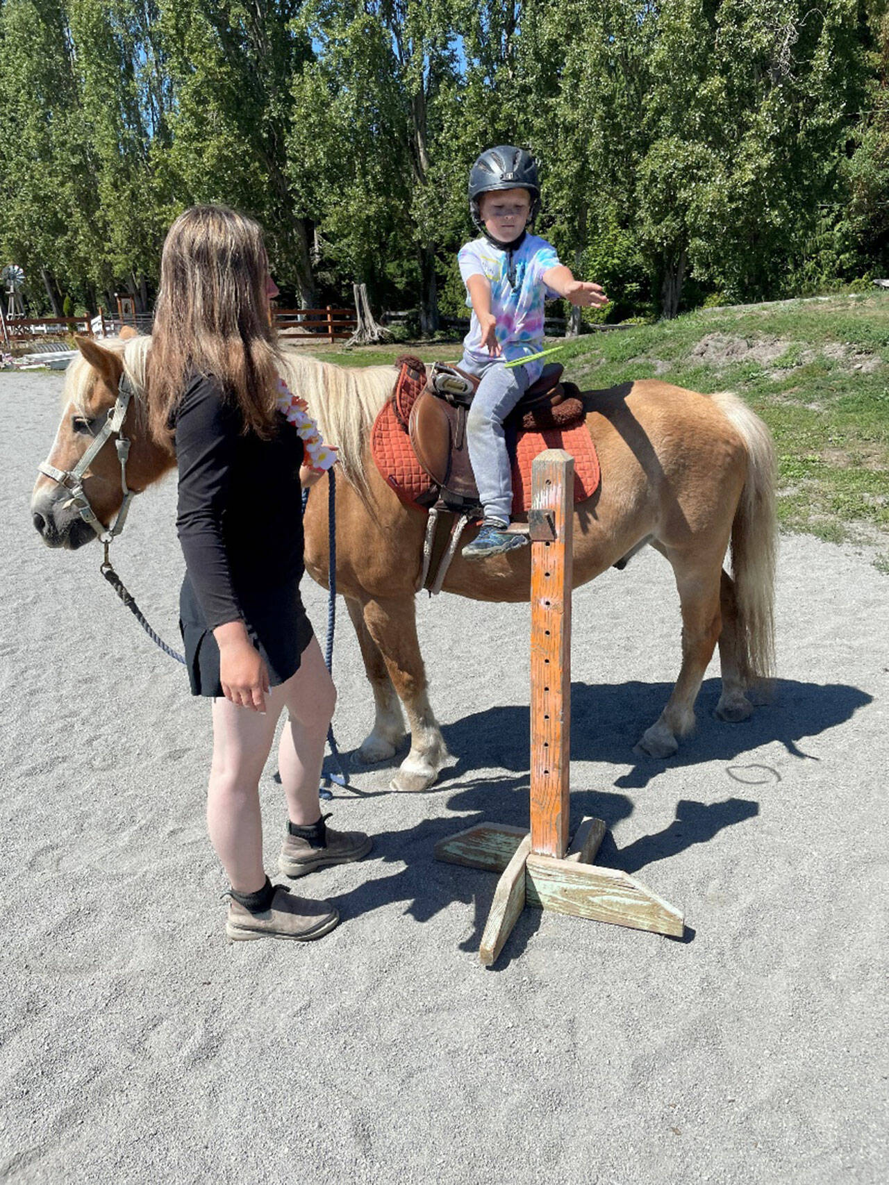 50 young ones signed up to take part in Fox-Bell Farm Trainings Hawaiian themed Kids Camp last weekend, including McCoy Sprenger, 7, on Moon, who played a ring toss game as instructor Sofie Feik looked on. (Photo by Mike Sprenger)