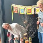 Debra E. Olson, left, and Leslie Dickinson install Birds of a Feather in the Fiber Habit walk-by exhibit of Peninsula Fiber Artists, 675 Tyler St. in Uptown Port Townsend.