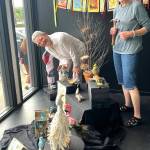 Debra E. Olson, left, and Leslie Dickinson install Birds of a Feather in the Fiber Habit walk-by exhibit of Peninsula Fiber Artists, 675 Tyler St. in Uptown Port Townsend.