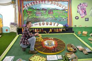 Erin Moilanen of the Crescent Grange arranges the groups display in preparation for the Clallam County Fair on Tuesday in Port Angeles. (Keith Thorpe/Peninsula Daily News)