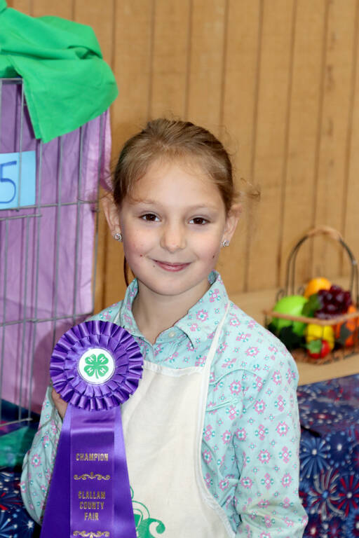 Anna-Marie Tax poses with the champion ribbon she won for decorating her cat Priscillas cage. (Dave Logan/For Peninsula Daily News)