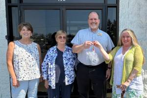 Eileen Schmitz, JACE Real Estate owner and Shipley Center board member, presents the keys of the former JCPenney building at 651 W. Washington St. to Shipley Center executive director Michael Smith following the centers Aug. 8 purchase of the building. At far left is Joyce Gladen of JACE Real Estate, and second from left is Shipley Center board secretary Margaret Cox. (Shipley Center)