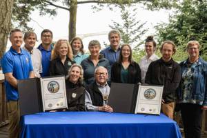 Martha Williams, director of the U.S. Fish & Wildlife Service, and Ron Allen, CEO and chairman of the Jamestown SKlallam Tribe (both seated), celebrate the signing of a co-stewardship agreement for the Dungeness and Protection Island National Wildlife Refuges on Aug. 16. (Jamestown SKlallam Tribe)