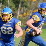 KEITH THORPE/PENINSULA DAILY NEWS Crescent quarterback Henry Bourm, right, looks to pass while teammate Thomas Leonard fends off the Concrete defense on Saturday in Joyce.