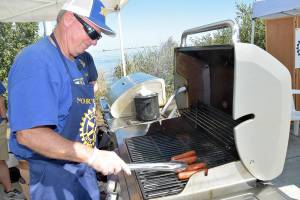NorWester Rotary member Chris Szczepczynski turns hot dogs for sale at Jammin in the Park on Saturday at Pebble Beach Park on the Port Angeles waterfront. (Keith Thorpe/Peninsula Daily News)