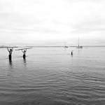 During an overhead static press lift and walk of a log, Port Townsend High School athletes Manaseh Lanphear Ramirez and Grady White both opted to challenge themselves above their knees, while Silas Klontz submerged himself beyond his armpits.