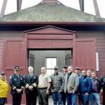 From left, Jefferson County Commissioner Heidi Eisenhour, Port Townsend Police Chief Thomas Olson, East Jefferson Fire Rescue Chief Bret Black, Jefferson County Sheriff Joe Nole, Mitchell Cartmel, Brandon Brown (back), Deputy Fire Marshal Brian Tracer, Andy Gosnell (back), Gabriel Shepherd, Ted Krysinski, Sam Neville and Officer Trevor Hansen stand in front of the Port Townsend Bell Tower on Wednesday. (Elijah Sussman/Peninsula Daily News)