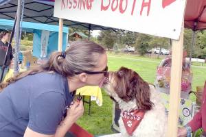 Mary Kniskern of Sonnys Spaw and Self-Wash of Sequim gets a kiss from Winston at a kissing booth set up for Music Where You Bark for KSQM Pet Lovers Day at the James Center for the Performing Arts on Saturday in Sequim. The event featured animal-oriented display booths and live music and animal demonstrations. (Keith Thorpe/Peninsula Daily News)