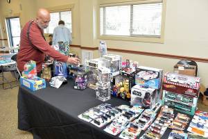 Paulo Leite of Port Angeles sets up a display of automotive and Star Wars toys at Saturdays Olympic Peninsula Toy and Collectibles Show at Guy Cole Convention Center in Sequim. The exhibition featured a wide variety of toys and collectible items for display, sale or trade. (Keith Thorpe/Peninsula Daily News)