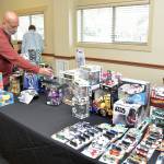 Paulo Leite of Port Angeles sets up a display of automotive and Star Wars toys at Saturdays Olympic Peninsula Toy and Collectibles Show at Guy Cole Convention Center in Sequim. The exhibition featured a wide variety of toys and collectible items for display, sale or trade. (Keith Thorpe/Peninsula Daily News)
