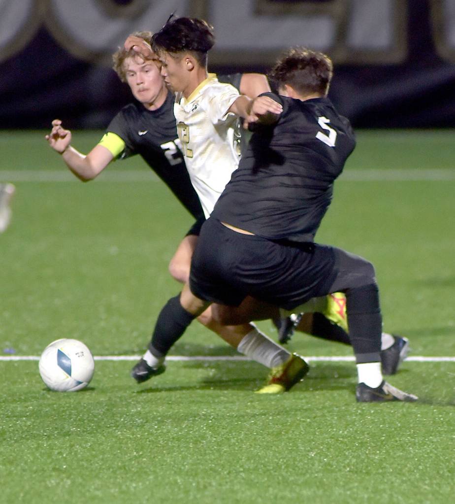 KEITH THORPE/PENINSULA DAILY NEWS Peninsulas Koya Kimura, center, breaks through the defense of Everetts Noah Harrison-Russell, left, and Dilon Spahia on Wednesday in Port Angeles.