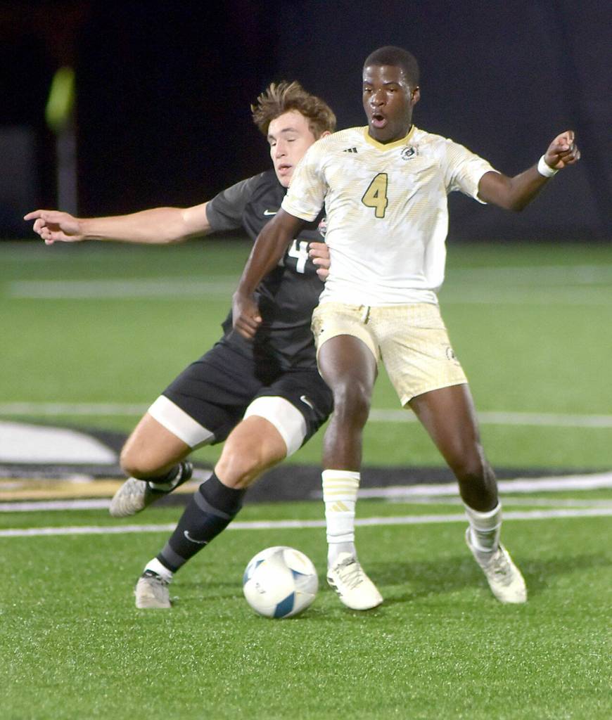 KEITH THORPE/PENINSULA DAILY NEWS Peninsulas Jeremie Kuelo, front, defends the ball from Everetts Caleb Hirata during Wednesdays match at Wally Sigmar Field.