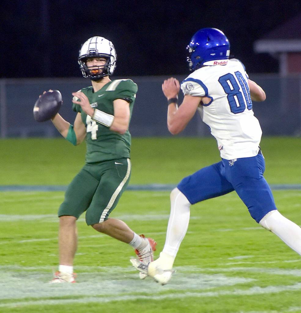KEITH THORPE/PENINSULA DAILY NEWS Port Angeles quarterback Blake Sohlberg looks to pass as North Masons Derek Dunham on Friday in Port Angeles.