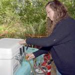 Moya Cavanagh, a teacher with Olympic Nature Experience, pours a taster glass with beer during Saturdays Beer in the Woods at Websters Woods at the Port Angeles Fine Arts Center. The event featured food, music, youth activities and samples of various breweries around Northwest Washington. (Keith Thorpe/Peninsula Daily News)