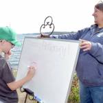 Grant Fairchild, 9, of Port Angeles plays Pictionary as Feiro Marine Life Center executive director Melissa Williams holds the drawing board outside the center on Saturday. Feiro hosted Day of Play with a variety of childrens activities geared toward conservation and the marine environment. (Keith Thorpe/Peninsula Daily News)