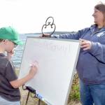 Grant Fairchild, 9, of Port Angeles plays Pictionary as Feiro Marine Life Center executive director Melissa Williams holds the drawing board outside the center on Saturday. Feiro hosted Day of Play with a variety of childrens activities geared toward conservation and the marine environment. (Keith Thorpe/Peninsula Daily News)