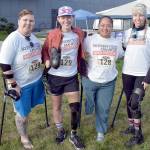 Members of the So Every BODY Can Move teams competing at the Big Hurt get await their mountain bike teammates Saturday at Pebble Beach in Port Angeles. From left are Katya Madden (kayak), Nicole Ver Kuilen (cycling, running), Sierra Landholm (kayak) and Katy Gaastra (cycling). The group is working to require insurance companies to help pay for orthotics and prosthetics so people can not only be mobile but to be able to run and cycle. (Keith Thorpe/Peninsula Daily News)