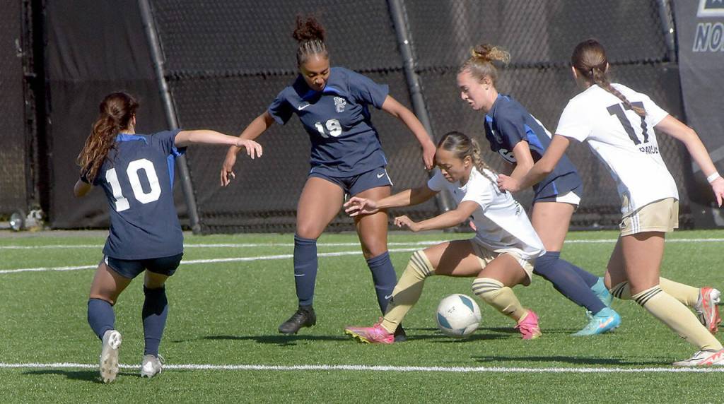 KEITH THORPE/PENINSULA DAILY NEWS Peninsulas Jaeda Mae Edayan, center, holds tight with the ball surrounded by, from left, Bellevues Macie Masterson, Galiala Abeye, and Layne Davis, and PeninsulasEmma Crystal on Wednesday at Peninsula College.