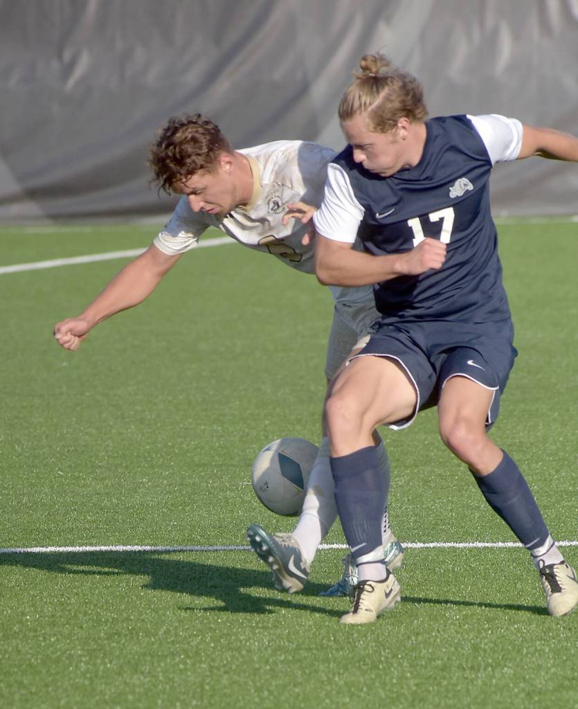 KEITH THORPE/PENINSULA DAILY NEWS Peninsulas Konrad Muller, left battles for the ball with Bellevues Kel Isar on Wednesday in Port Angeles.