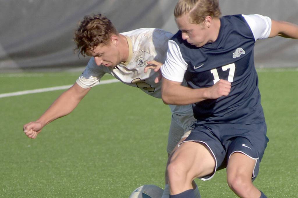 KEITH THORPE/PENINSULA DAILY NEWS
Peninsula's Konrad Muller, left battles for the ball with Bellevue's Kel Isar on Wednesday in Port Angeles.