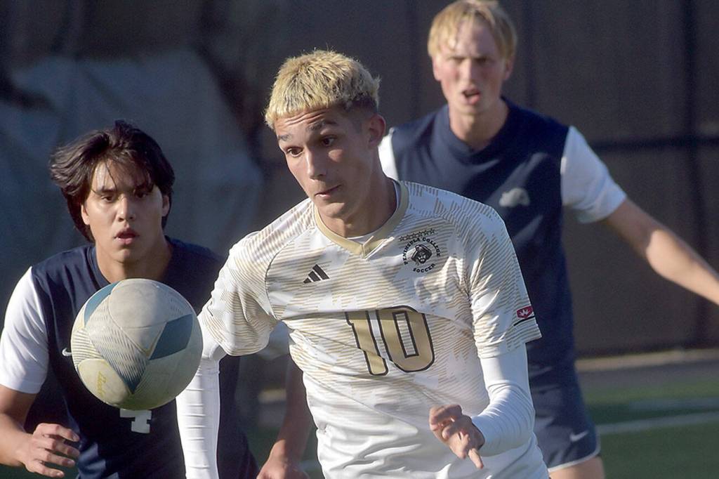 KEITH THORPE/PENINSULA DAILY NEWS
Peninsula's Nil Grau, front, chases a loose ball pursued by Bellevue's Patrick Gloria, left, and Beckett Heynen, rear, during Wednesday's match at Peninsula College.