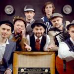 Bagrat Tsurkan (vocals) in center. Clockwise from the bottom left, Volodymyr Gitin (clarinet), Andrei Okhramovich (trumpet), Yaroslav Besh (trombone), Sergei Poltorak (percussion), Oleg Vasianovich (accordion) and Viktor Kirilov (acoustic guitar).