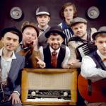 Bagrat Tsurkan (vocals) in center. Clockwise from the bottom left, Volodymyr Gitin (clarinet), Andrei Okhramovich (trumpet), Yaroslav Besh (trombone), Sergei Poltorak (percussion), Oleg Vasianovich (accordion) and Viktor Kirilov (acoustic guitar).