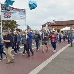 Participants in the Womens March for Humanity cross Sequim Avenue at Washington Street in downtown Sequim on Saturday, part of a rally for U.S. presidential candidate Kamala Harris and running mate Tim Walz. The group of about 200 participants marched from Centennial Place Park to Fifth Avenue and back. (Keith Thorpe/Peninsula Daily News)