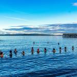 About two dozen took part in a community cold plunge in the 48-degree waters of Port Townsend Bay on Thursday to celebrate the biggest super moon of the year. Although the moon wasnt due to rise for at least another hour, that didnt dampen the participants entry into the bay next to the Port Townsend Marine Science Center aquarium. (Steve Mullensky/for Peninsula Daily News)