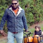 Patrick Young of Sequim pulls a cart containing his son, Ellis Young, 2 1/2, and freshly picked pumpkins on Saturday at the pumpkin patch at Agnew Grocery east of Port Angeles. The family was out in a light rain to collect the perfect Jack o Lantern for Halloween. (Keith Thorpe/Peninsula Daily News)