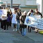 Participants in the a walk to raise awareness of domestic violence make their way down First Street on a journey from the Elwha Heritage Center to Healthy Families of Clallam County in Port Angeles on Wednesday. The event also included resource booths, shared stories and food and beverages, hosted by the Lower Elwha Klallam Tribe. (Keith Thorpe/Peninsula Daily News)