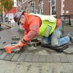 Ian Mason of Edgewood, an employee of Titan Earthworks, hammers a brick paver into place at the corner of First and Oak streets in downtown Port Angeles on Wednesday as part of a project to replace and repair sidewalks and curbs across the city. Included are the installation of improved wheelchair ramps, replacement of overgrown trees and numerous street corner repairs. (Keith Thorpe/Peninsula Daily News)